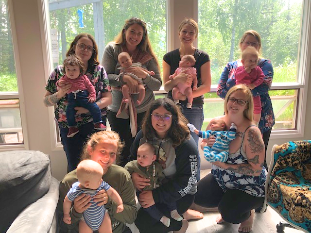 Seven moms holding their babies at an EPSA parent peer-support group meeting. 