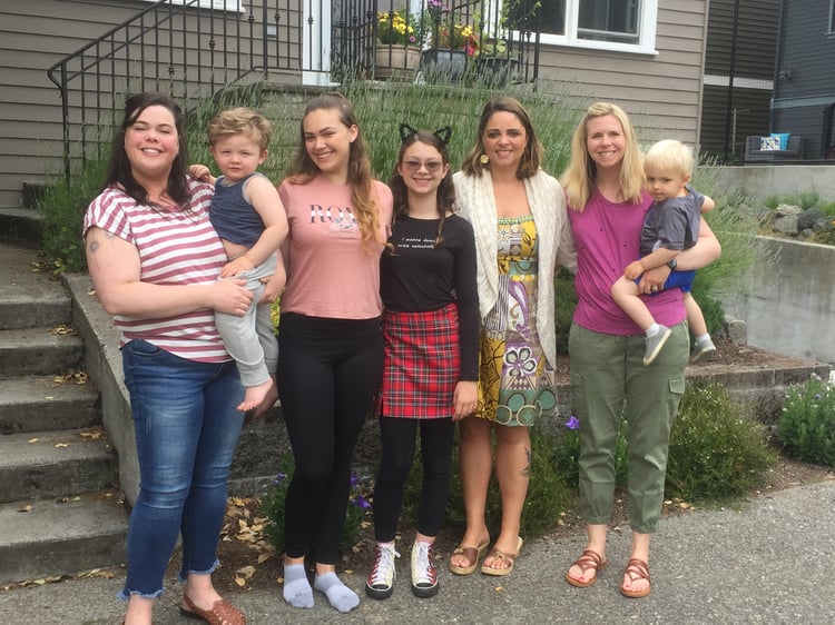 Three sisters and their children standing in front of house