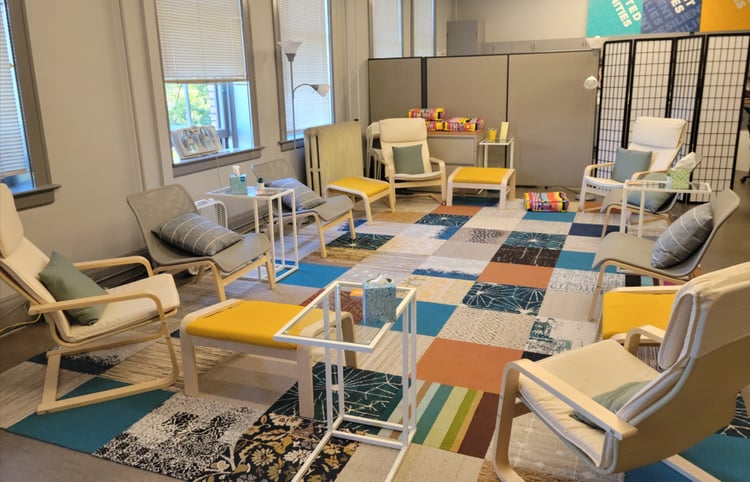 carpeted space filled with lounge chairs and coffee tables