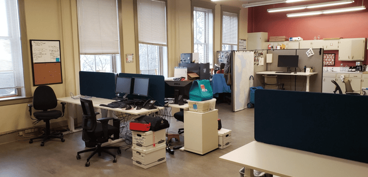 open office space with desks, chairs, and office supplies