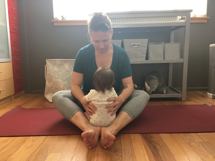 Megan facing baby on a yoga mat