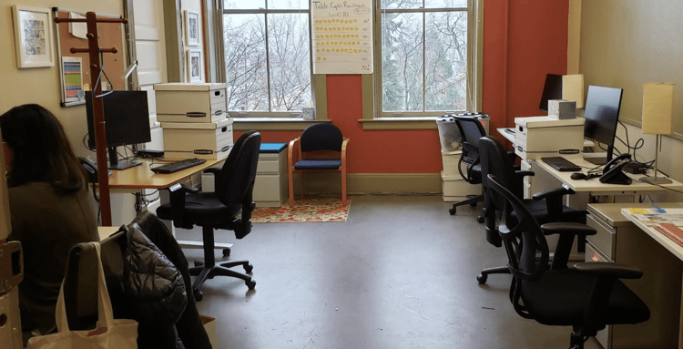 open office space with desks, chairs, and office supplies