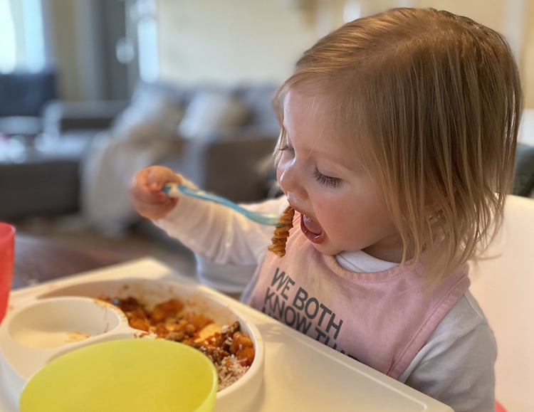 child eating pasta