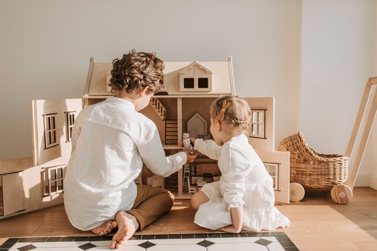 Two siblings playing with a dollhouse together. Image courtesy of Vlada Karpovich via Pexels.
