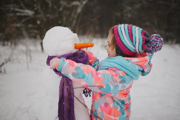 Little girl making a snowman