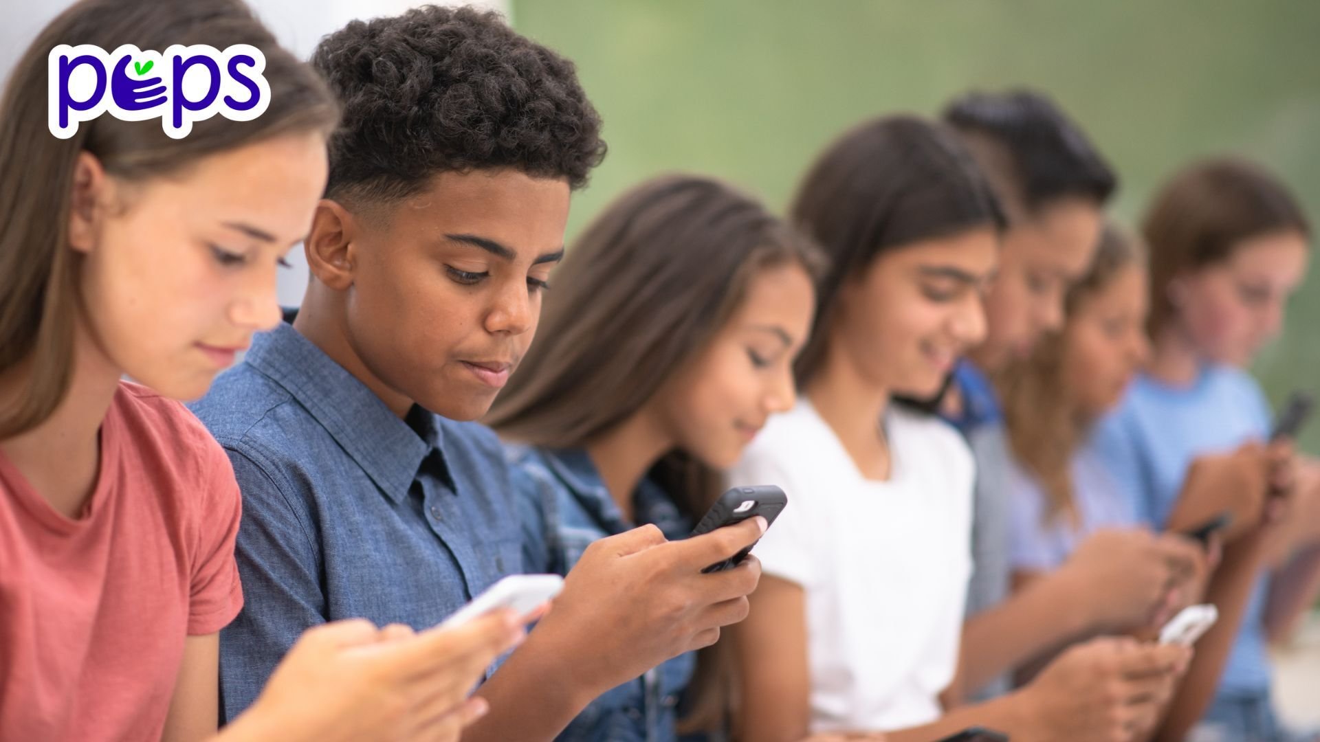 A group of teens in a line on their phones.